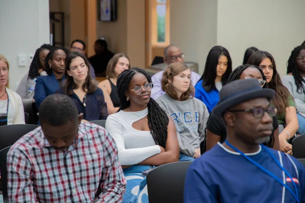 Audience members seated and listening to a presentation.